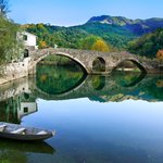 A stone-arched bridge reflected in the Crnojevića river in Montenegro