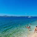 Beachgoers wade in the crystalline waters of the Adriatic Sea near Zadar