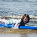 Girl taking surfing lessons in Co. Donegal