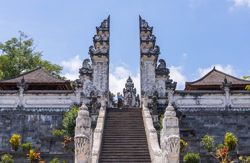 BALI, INDONESIA - SEPTEMBER 17, 2019: Couple at the entrance temple of Pura Penataran Agung Lempuyang. In Bali, Indonesia