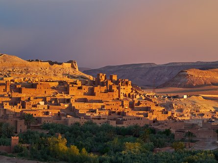 The sun sets over the Ouarzazate River and Aït Benhaddou