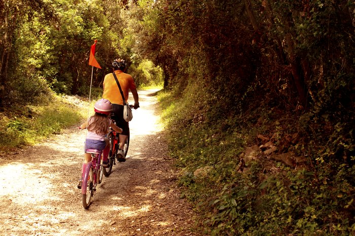 A father and daughter duo ride the tree-lined trails of Park šuma Zlatni Rt near Rovinj