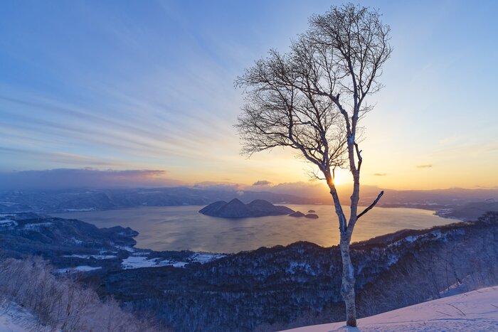 Cruise across the tranquil waters of Lake Toya, enjoying panoramic views of snowcapped mountains