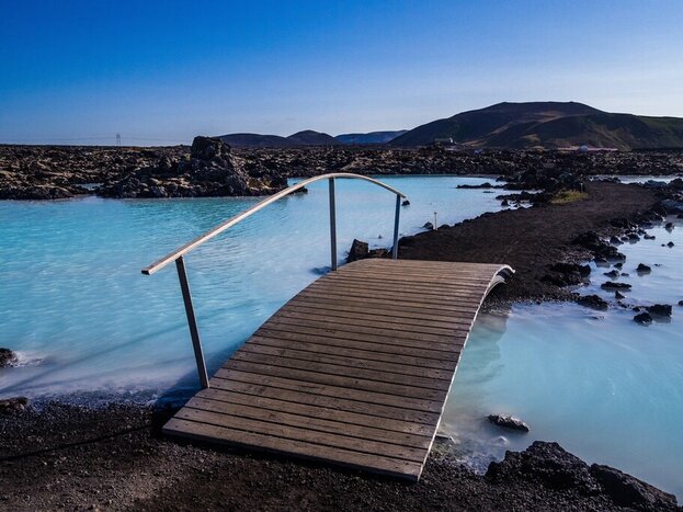 A bridge crosses the milky blue mineral waters of the Blue Lagoon, a classic stop outside of Reykavík
