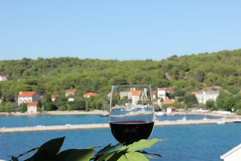 A glass of wine with a view on Zlarin island, Croatia