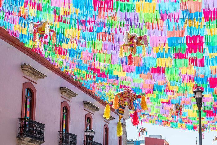 Colorful flags and piñatas on a street in Oaxaca