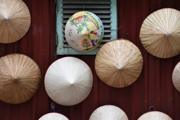 Traditional Vietnamese paper hats on a wall in Hanoi