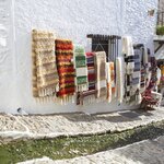 Pampaneira's Calle del Agua carries water past traditional woven rugs and through the village