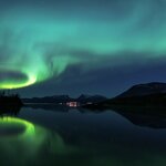 Northern lights reflect in Lake Torneträsk over Abisko in Swedish Lapland