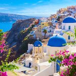 Look out at the glittering sea and colorful buildings in Oia