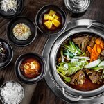 Indulge in savory pork bone hot pot with traditional Korean "banchan"