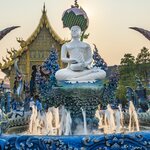 Fly to Chiang Rai from Bangkok where you'll see Wat Rong Suea Ten, also known as the Blue Temple