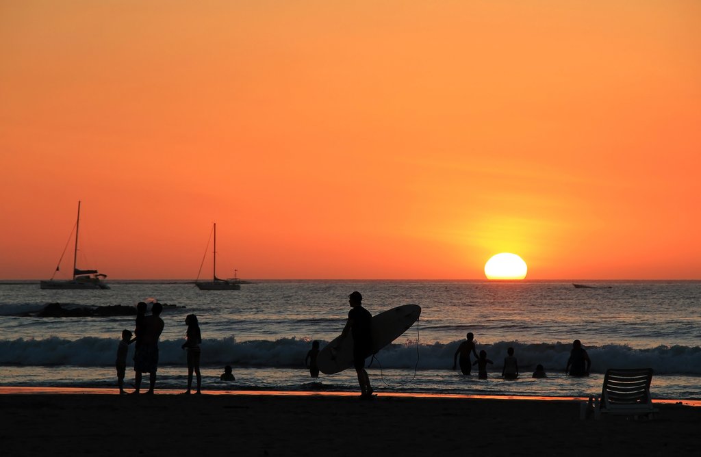 A surfer at sunset on Playa Tamarindo