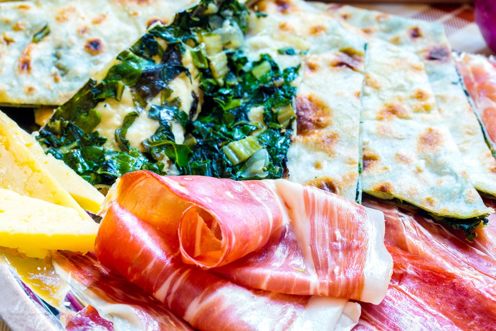 Plate of soparnik (a type of savory pie) with prosciuto and cheese