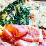 Plate of soparnik (a type of savory pie) with prosciuto and cheese