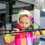 Adorable kid in colorful coat looking at water from the touring boat, Te Anau, New ZealandFamily frolicking in the sea near Auckland