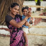Indian woman and baby in her arms are smiling with very good mood