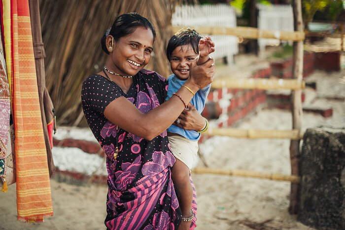 Indian woman and baby in her arms are smiling with very good mood