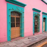 Bright pink building with blue shutters in colorful Oaxaca City
