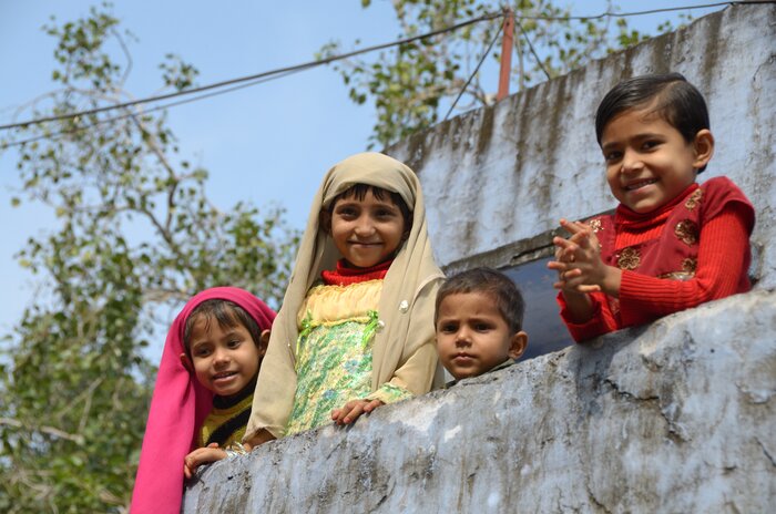 Children peek over a balcony near Jaipur
