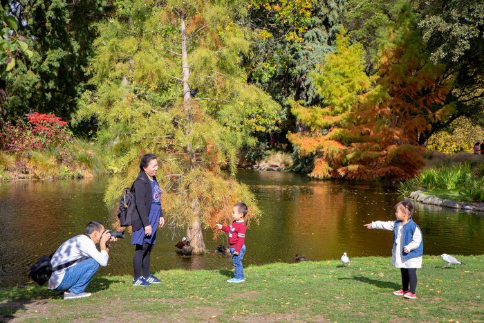 A father snaps pics of his children on holiday in the Botanic Gardens in Christchurch, New Zealand