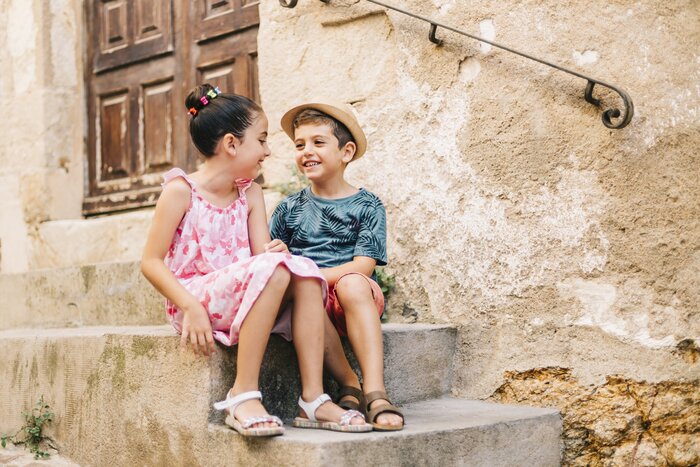 Children sitting on stone steps in Spain