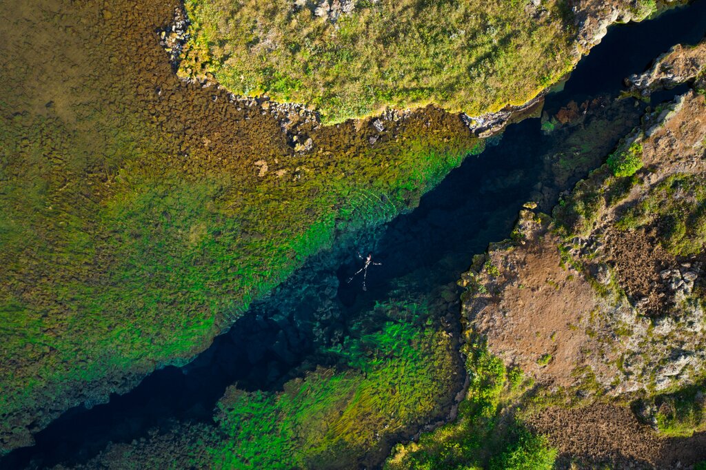 aerial shot of a person floating in Silfra fissure