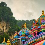 A monkey on a colorful rooftop at the Batu Caves
