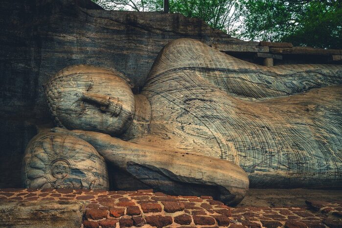 Discover a reclining Buddha among the well-preserved ruins of Polonnaruwa, Sri Lanka's medieval capital