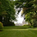 A grand estate overlooks manicured gardens in 