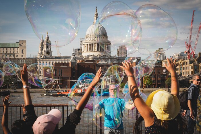 A street performer on the banks of the Thames with St Paul's Cathedral in the background