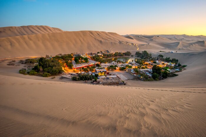Visit Huacachina, a desert village and small oasis, surrounded by sand dunes