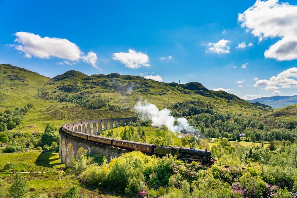 Glenfinnan Railway Viaduct in Scotland with the steam train passing over