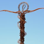 Outside the Memorial Church of Moses is an enigmatic serpentine cross, the Brazen Serpent Monument.   Created by Italian artist Giovanni Fantoni, it imaginatively merges the life-saving bronze serpent set up on a pole by Moses to protect the Israelites from "fiery serpents" in the desert (Numbers 21:4-9) and the cross upon which Jesus was crucified.  - Memorial of Moses Church, Mount Nebo, Jordan | Photo taken by Rich W