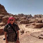 Rich hiked up the trail to the High Place of Sacrifice, where offerings of animals were made to the gods.  Here, the theater and part of the Street of Facades is in the background.   Our guide, Akram, had given Brad and me the scarves that local men use as headgear, tied in a variety of ways. Clearly, I had not yet mastered the art of tying the keffiyeh!  - Petra, Jordan | Photo taken by Rich W