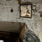 This photo is taken one floor down from the previous picture of the top of Golgotha. There is a rift in the rock (viewed through the window in the upper center of the photo) attributed to the earthquake that occurred at the time of Jesus’ death, according to the Gospel of Matthew.  You can see further down the rock of the Golgotha hill beneath the glass floor.  - Church of the Holy Sepulchre, Jerusalem, Israel | Photo taken by Rich W