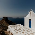 Santorini -  hundreds of white stone churches with their iconic blue domes and the white crosses topping them. | Photo taken by Kris M